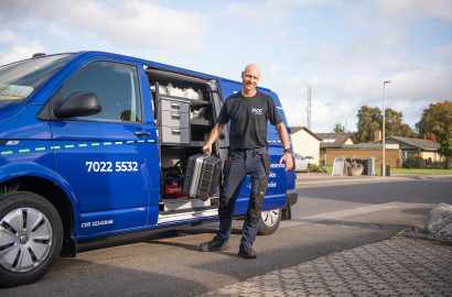 Servicetekniker foran sin bil i villakvarter