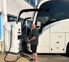 Glad mand oplader en hvid bus