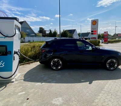 Sort elbil lader op ved Shell station