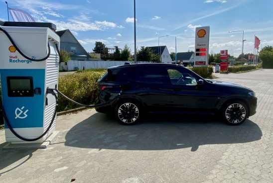 Sort elbil lader op ved Shell station